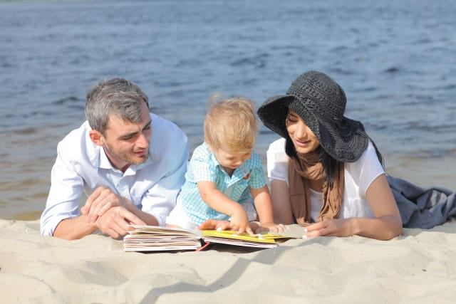 砂浜で絵本を読む家族