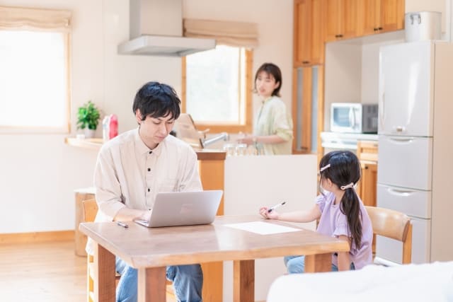 家事をする女性とダイニングにいる家族